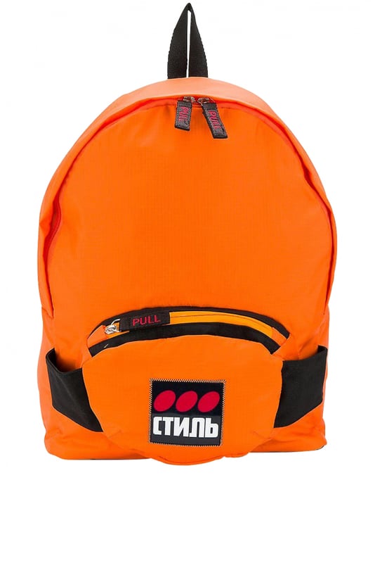 Heron Preston rugzak van oranje stof.Groot vak met rits.Klein vak met rits aan de voorkant.Klein zwart handvat aan de bovenkant.Verstelbare zwarte bandjes.Patch met  Стиль  inscripties op het voorvak.Afmetingen: 33x44x14cm.Gemaakt in Italië.
