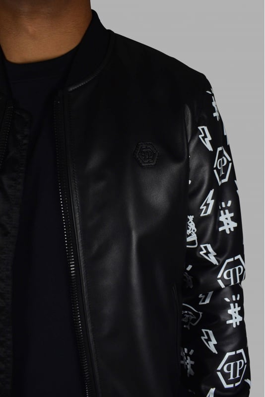 Chaqueta bomber Philipp Plein de piel negra con cierre de cremallera.Detalles de diseños blancos en las mangas de piel.Elástico negro en cintura y puños.Placa con logo de PP negro en la parte delantera.Bolsillos laterales.Made in Italy.