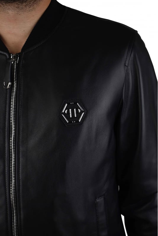 Cazadora bomber de Philipp Plein en suave piel negra.Detalles en metal plateado.Logotipo «PP» hexagonal en metal negro en el pecho.Cremallera central.Cuello alto con ribetes de canalé. Dos bolsillos laterales con botón de presión.Ribetes de canalé.Made in Italy.