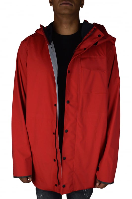 Rote Jacke im Stil von K-Way Y/Project Canada Goose.Stehkragen mit Kapuze.Reißverschluss mit Druckknöpfen.Lange Ärmel.Reflektierende Streifen auf der Rückseite.Aufgenähte Logo-Patches auf dem linken Ärmel.Klettverschlussstreifen zum Verengen an den Ärmeln.Zwei Seitentaschen mit Reißverschluss.Tasche mit Klettverschluss auf der linken Brust.