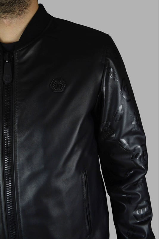 Chaqueta bomber Philipp Plein de piel negra con cierre de cremallera.Detalles de diseños negros en las mangas de piel.Elástico negro en cintura y puños.Placa con logo de PP negro en la parte delantera.Bolsillos laterales.Made in Italy.