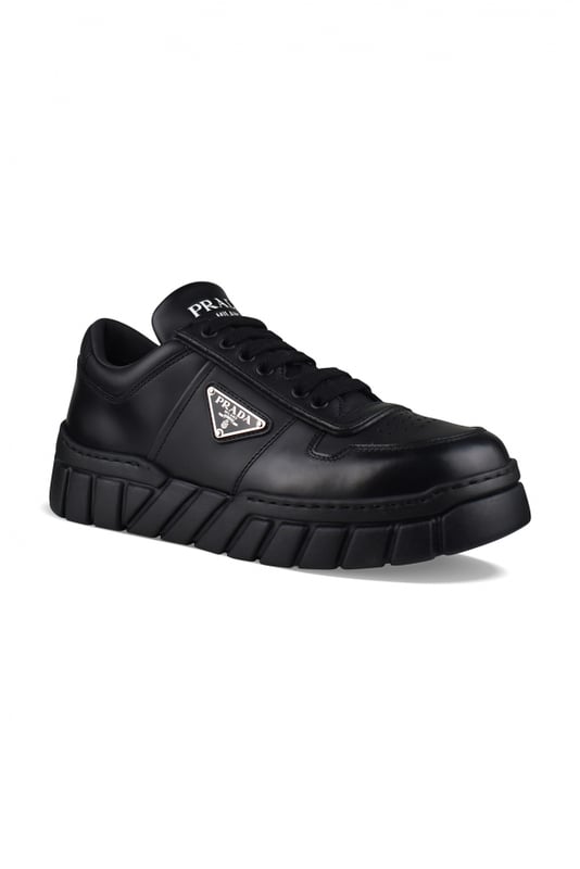 Sneakers de piel negra de Prada.Logotipo triangular de metal esmaltado en el exterior.Parte superior perforada en la parte delantera de la zapatilla.Cierre de cordones negro.Firma Prada blanca en la lengüeta delantera y en el contrafuerte. Suela gruesa de goma.Made in Italy.