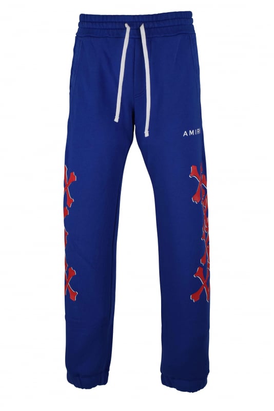 Amiri joggingbroek van blauw katoen.Witte logoprint op de voorkant.Rode botprints langs de pijpen.Elastische tailleband met trekkoorden.Elastische enkels.Zijzakken.Eén achterzak.Zwarte logopatch op de achterkant.Gemaakt in Italië.