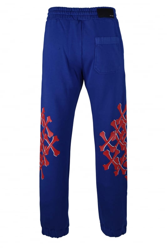 Amiri joggingbroek van blauw katoen.Witte logoprint op de voorkant.Rode botprints langs de pijpen.Elastische tailleband met trekkoorden.Elastische enkels.Zijzakken.Eén achterzak.Zwarte logopatch op de achterkant.Gemaakt in Italië.