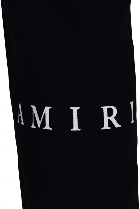 Pantalón jogging Amiri de algodón negro.Pequeño estampado blanco «MA» en la parte delantera de una pierna.Estampado blanco «Amiri» en la parte trasera de una pierna.Cintura elástica con cordones blancos.Logotipo negro en la parte trasera.Bolsillos laterales.Un bolsillo trasero.Tobillos elásticos con cordones.Made in Italy.