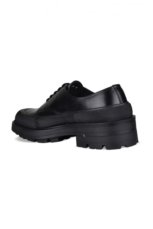 Derbies Alexander McQueen de piel negra.Detalles de costuras.Logotipo en relieve en la lengüeta.Cierre de cordones en negro.Puntera cuadrada.Suela gruesa de goma en contraste con logotipo.Made in Italy.