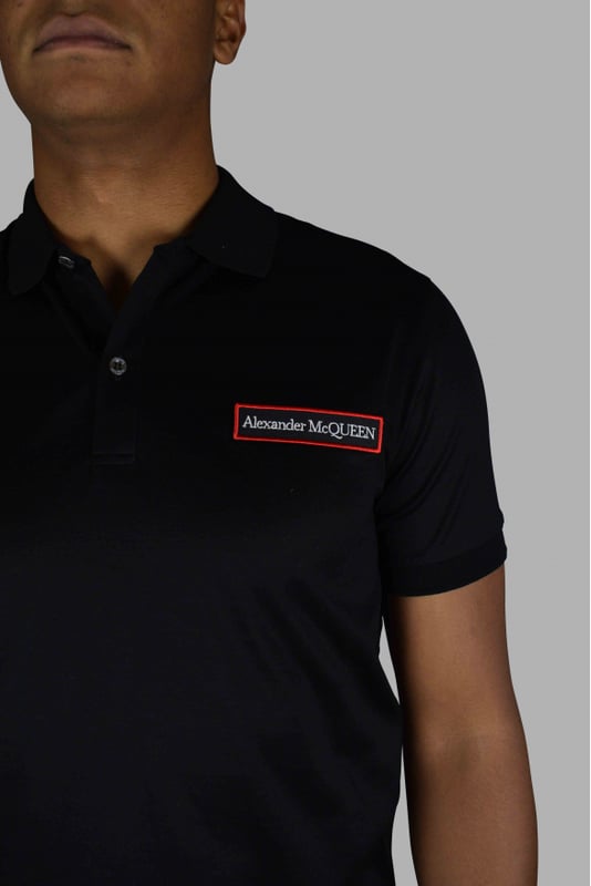 Polo negro de Alexander McQueen.Parche con logo cosido en la parte delantera.Dos botones en la parte delantera.100% algodón.Made in Italy.