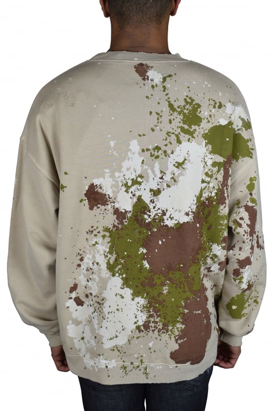 Sudadera Dsquared2 beige con manchas de pintura.Múltiples manchas de pintura de color caqui, marrón y blanco en la parte delantera y trasera.Logotipo negro  Dsquared2  en la parte delantera.Bolsillo tipo canguro en la parte delantera.Cuello redondo.100% algodón.Made in Italy.