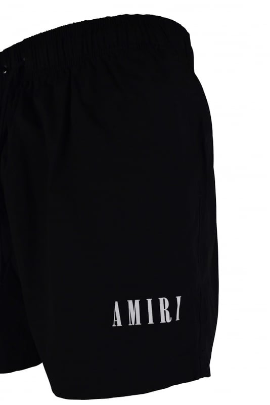 Shorts de baño Amiri negros de poliéster y elastano.Logotipo «Amiri» blanca estampado en el bajo.Cintura elástica con cordones.Bolsillos laterales.Un bolsillo trasero con cierre de velcro.Parche con logotipo negro en la espalda.