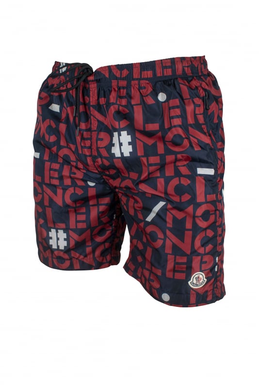 Bañador Moncler de nylon azul oscuro.Logotipos rojos y blancos estampados.Parche con logotipo bordado en la parte inferior.Bolsillos laterales con cremallera.Un bolsillo trasero con cremallera.Cintura elástica.