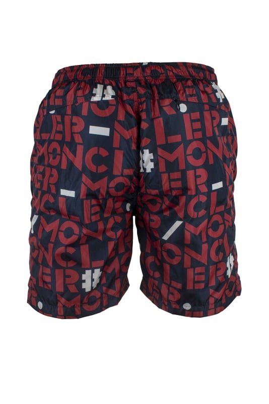 Bañador Moncler de nylon azul oscuro.Logotipos rojos y blancos estampados.Parche con logotipo bordado en la parte inferior.Bolsillos laterales con cremallera.Un bolsillo trasero con cremallera.Cintura elástica.