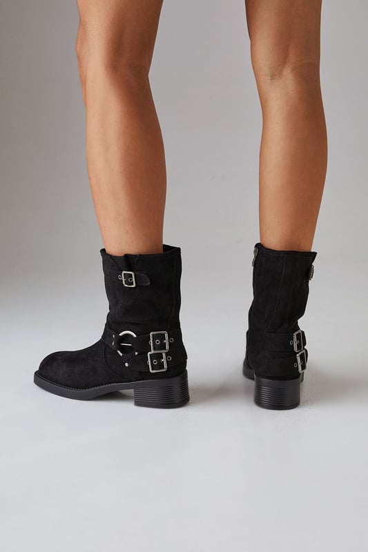 Faux suede chunky biker calf boots
        Mid-heel height between 5 and 6.5cm
        Decorative buckle and strap detailing
        Side zip closure for easy wear
        Sturdy block heel for comfort and stability
    
    Step out in style with these Faith Eostre faux suede chunky biker calf boots. The edgy design combines comfort and fashion, making them perfect for various casual outings. The mid-heel height offers a subtle lift without compromising on wearability, ideal for all-day adventures. Style these versatile boots with a flowy mini skirt and an oversized jumper for a chic autumn look, or pair them with skinny jeans and a leather jacket for a classic biker-inspired ensemble. These boots are your go-to choice for family gatherings, weekend brunches, or casual shopping trips. Their robust construction and timeless appeal ensure they'll be a staple in your wardrobe for seasons to come, effortlessly transitioning from day to night with their adaptable style.
