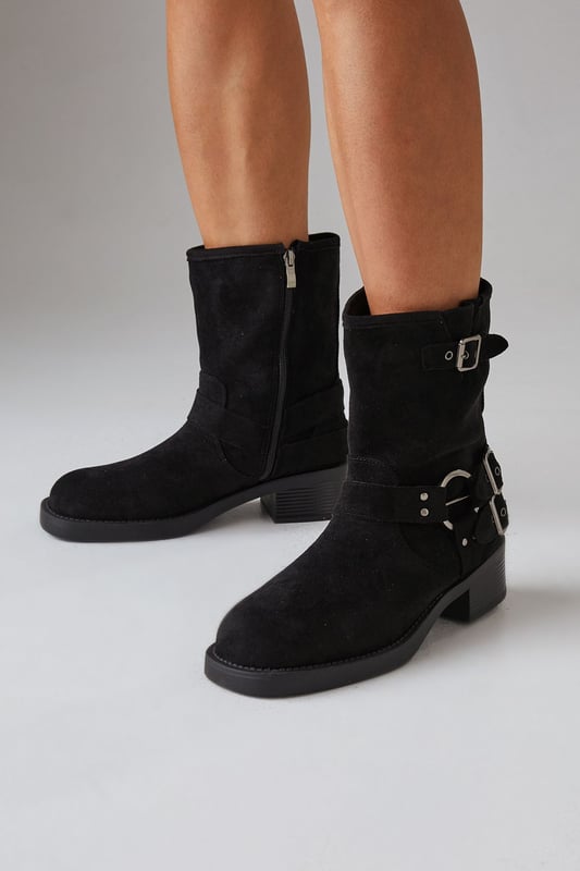Faux suede chunky biker calf boots
        Mid-heel height between 5 and 6.5cm
        Decorative buckle and strap detailing
        Side zip closure for easy wear
        Sturdy block heel for comfort and stability
    
    Step out in style with these Faith Eostre faux suede chunky biker calf boots. The edgy design combines comfort and fashion, making them perfect for various casual outings. The mid-heel height offers a subtle lift without compromising on wearability, ideal for all-day adventures. Style these versatile boots with a flowy mini skirt and an oversized jumper for a chic autumn look, or pair them with skinny jeans and a leather jacket for a classic biker-inspired ensemble. These boots are your go-to choice for family gatherings, weekend brunches, or casual shopping trips. Their robust construction and timeless appeal ensure they'll be a staple in your wardrobe for seasons to come, effortlessly transitioning from day to night with their adaptable style.