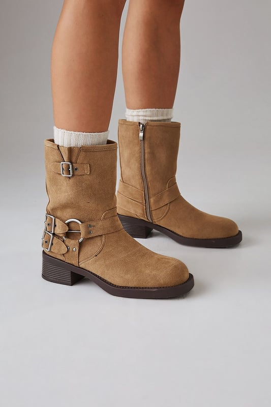 Faux suede chunky biker calf boots
        Mid-heel height between 5 and 6.5cm
        Decorative buckle and strap detailing
        Side zip closure for easy wear
        Sturdy block heel for comfort and stability
    
    Step out in style with these Faith Eostre faux suede chunky biker calf boots. The edgy design combines comfort and fashion, making them perfect for various casual outings. The mid-heel height offers a subtle lift without compromising on wearability, ideal for all-day adventures. Style these versatile boots with a flowy mini skirt and an oversized jumper for a chic autumn look, or pair them with skinny jeans and a leather jacket for a classic biker-inspired ensemble. These boots are your go-to choice for family gatherings, weekend brunches, or casual shopping trips. Their robust construction and timeless appeal ensure they'll be a staple in your wardrobe for seasons to come, effortlessly transitioning from day to night with their adaptable style.