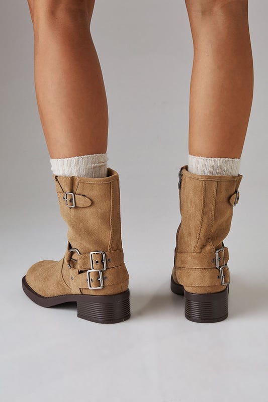 Faux suede chunky biker calf boots
        Mid-heel height between 5 and 6.5cm
        Decorative buckle and strap detailing
        Side zip closure for easy wear
        Sturdy block heel for comfort and stability
    
    Step out in style with these Faith Eostre faux suede chunky biker calf boots. The edgy design combines comfort and fashion, making them perfect for various casual outings. The mid-heel height offers a subtle lift without compromising on wearability, ideal for all-day adventures. Style these versatile boots with a flowy mini skirt and an oversized jumper for a chic autumn look, or pair them with skinny jeans and a leather jacket for a classic biker-inspired ensemble. These boots are your go-to choice for family gatherings, weekend brunches, or casual shopping trips. Their robust construction and timeless appeal ensure they'll be a staple in your wardrobe for seasons to come, effortlessly transitioning from day to night with their adaptable style.