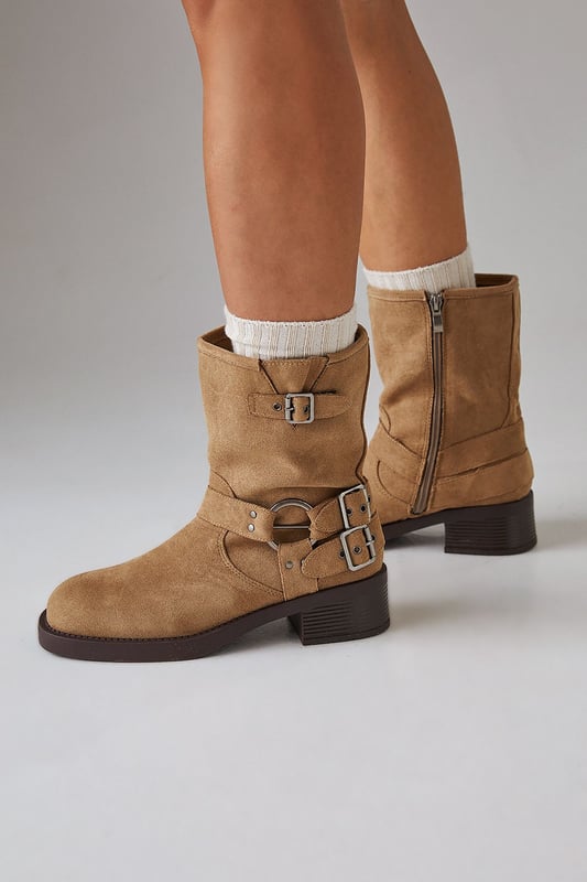 Faux suede chunky biker calf boots
        Mid-heel height between 5 and 6.5cm
        Decorative buckle and strap detailing
        Side zip closure for easy wear
        Sturdy block heel for comfort and stability
    
    Step out in style with these Faith Eostre faux suede chunky biker calf boots. The edgy design combines comfort and fashion, making them perfect for various casual outings. The mid-heel height offers a subtle lift without compromising on wearability, ideal for all-day adventures. Style these versatile boots with a flowy mini skirt and an oversized jumper for a chic autumn look, or pair them with skinny jeans and a leather jacket for a classic biker-inspired ensemble. These boots are your go-to choice for family gatherings, weekend brunches, or casual shopping trips. Their robust construction and timeless appeal ensure they'll be a staple in your wardrobe for seasons to come, effortlessly transitioning from day to night with their adaptable style.