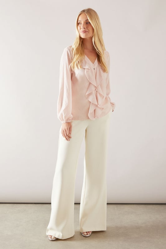 Elegant V-neckline with cascading ruffle front detail for a sophisticated finish
        Long sleeves with gentle elasticated cuffs for a graceful silhouette
        Lightweight woven fabric with delicate sheen perfect for special occasions
        Petite fit designed specifically for smaller frames with proportionate length
        Subtle button fastening detail enhancing the feminine aesthetic
    
    This Wallis Petite Occasion Hotfix Ruffle Front Blouse brings glamour to your formal wardrobe with its flowing cascading ruffle detail. The elegant V-neckline frames the dcolletage beautifully, while the long sleeves create a balanced silhouette. Style with wide-leg trousers as shown for a contemporary take on occasion dressing, or pair with a tailored pencil skirt for a more traditional ensemble. Perfect for weddings, race days and graduations, this blouse transitions effortlessly from day to evening events. Add statement earrings and a clutch bag to complete your sophisticated look. The petite proportions ensure a flattering fit without overwhelming smaller frames, making this a versatile piece that will become a cornerstone of your special occasion collection.
