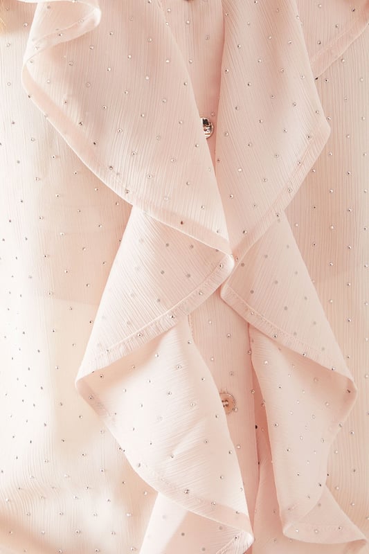 Elegant V-neckline with cascading ruffle front detail for a sophisticated finish
        Long sleeves with gentle elasticated cuffs for a graceful silhouette
        Lightweight woven fabric with delicate sheen perfect for special occasions
        Petite fit designed specifically for smaller frames with proportionate length
        Subtle button fastening detail enhancing the feminine aesthetic
    
    This Wallis Petite Occasion Hotfix Ruffle Front Blouse brings glamour to your formal wardrobe with its flowing cascading ruffle detail. The elegant V-neckline frames the dcolletage beautifully, while the long sleeves create a balanced silhouette. Style with wide-leg trousers as shown for a contemporary take on occasion dressing, or pair with a tailored pencil skirt for a more traditional ensemble. Perfect for weddings, race days and graduations, this blouse transitions effortlessly from day to evening events. Add statement earrings and a clutch bag to complete your sophisticated look. The petite proportions ensure a flattering fit without overwhelming smaller frames, making this a versatile piece that will become a cornerstone of your special occasion collection.