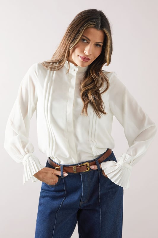 Elegant ruffle neck detail for a sophisticated touch
        Pleated front design adds texture and visual interest
        Long sleeves with gathered cuffs for a refined silhouette
        Versatile woven fabric suitable for various occasions
        Relaxed fit through the body for comfort and ease of movement
    
    This Wallis blouse radiates effortless sophistication with its ruffle neck and pleat detail. Perfect for the woman who appreciates both style and comfort, it's an ideal choice for daywear occasions. Style it with wide-leg trousers and a leather belt for a polished look at family gatherings or casual brunches. The long sleeves with gathered cuffs add a touch of elegance, making it suitable for slightly dressier daytime events. For a more relaxed ensemble, pair it with your favourite jeans and ballet flats. The versatile nature of this blouse allows for easy transition from a day at the office to an evening out with friends. Its timeless design ensures it will remain a staple in your wardrobe for seasons to come, offering endless styling possibilities for the fashion-forward woman who values both glamour and practicality.