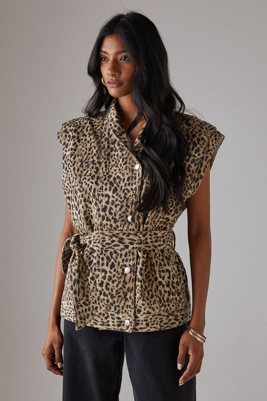 Sleeveless denim jacket with bold leopard print
        Funnel neck for a contemporary edge
        Boxy fit offering a modern silhouette
        Belted waist for a flattering, adjustable fit
        Button-through front for versatile styling options
    
    Make a statement with this eye-catching leopard print sleeveless denim jacket from Warehouse. The boxy fit and funnel neck create a contemporary silhouette that's perfect for the confident, fashion-forward woman. The belted waist allows for a customised fit, accentuating your figure while maintaining a relaxed feel. Ideal for casual events and family gatherings, this versatile piece can be styled in numerous ways. Layer it over a simple black tee and wide-leg trousers for a chic daytime look, or button it up and wear as a standalone top with your favourite jeans for an edgy evening ensemble. The sleeveless design makes it a great transitional piece, easily paired with long-sleeved tops for cooler days. Finish the look with gold hoop earrings and ankle boots to channel effortless urban style.