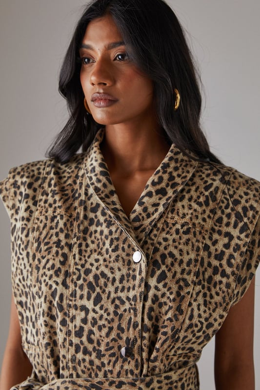 Sleeveless denim jacket with bold leopard print
        Funnel neck for a contemporary edge
        Boxy fit offering a modern silhouette
        Belted waist for a flattering, adjustable fit
        Button-through front for versatile styling options
    
    Make a statement with this eye-catching leopard print sleeveless denim jacket from Warehouse. The boxy fit and funnel neck create a contemporary silhouette that's perfect for the confident, fashion-forward woman. The belted waist allows for a customised fit, accentuating your figure while maintaining a relaxed feel. Ideal for casual events and family gatherings, this versatile piece can be styled in numerous ways. Layer it over a simple black tee and wide-leg trousers for a chic daytime look, or button it up and wear as a standalone top with your favourite jeans for an edgy evening ensemble. The sleeveless design makes it a great transitional piece, easily paired with long-sleeved tops for cooler days. Finish the look with gold hoop earrings and ankle boots to channel effortless urban style.