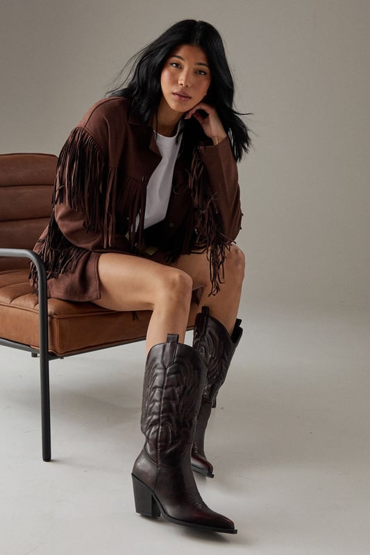 Striking western-inspired calf boots with intricate embroidered detailing
        Brushed faux leather finish for a sophisticated texture
        Pointed toe design with classic pull tabs for easy wear
        Statement 7-9cm block heel adds height whilst maintaining stability
        Calf-height shaft with distinctive western stitching pattern
    
    The Faith Nash Western Boots bring countryside charm to city streets with their distinctive embroidered detailing and brushed finish. The 7-9cm heel creates a flattering silhouette whilst remaining comfortable for all-day wear. Style these versatile boots with a floaty midi dress and oversized jacket for weekend brunches, or pair with straight-leg jeans and a crisp white tee for casual gatherings. For autumn outings, match with a mini skirt and fringed jacket to showcase the boots' western heritage. The pointed toe and sleek silhouette ensure these boots transition effortlessly from day to night, making them a wardrobe essential that combines practicality with statement style. Their classic design promises longevity beyond seasonal trends.