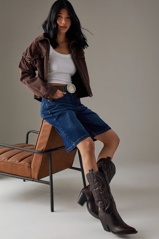 Striking western-inspired calf boots with intricate embroidered detailing
        Brushed faux leather finish for a sophisticated texture
        Pointed toe design with classic pull tabs for easy wear
        Statement 7-9cm block heel adds height whilst maintaining stability
        Calf-height shaft with distinctive western stitching pattern
    
    The Faith Nash Western Boots bring countryside charm to city streets with their distinctive embroidered detailing and brushed finish. The 7-9cm heel creates a flattering silhouette whilst remaining comfortable for all-day wear. Style these versatile boots with a floaty midi dress and oversized jacket for weekend brunches, or pair with straight-leg jeans and a crisp white tee for casual gatherings. For autumn outings, match with a mini skirt and fringed jacket to showcase the boots' western heritage. The pointed toe and sleek silhouette ensure these boots transition effortlessly from day to night, making them a wardrobe essential that combines practicality with statement style. Their classic design promises longevity beyond seasonal trends.