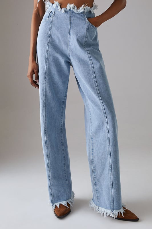 Wide leg silhouette with distinctive fray detailing at waistband and hem for an edgy finish
        Front seam detailing adds architectural interest and elongates the leg
        Cotton fabric provides comfort and breathability for all-day wear
        Practical side and back pockets for everyday functionality
        High-rise waist creates a flattering silhouette that pairs perfectly with cropped tops
    
    These Warehouse wide leg jeans combine contemporary design with effortless wearability. The striking fray detail along the waistband and hem creates a raw, fashion-forward aesthetic that sets these jeans apart from standard denim styles. Style them as shown with a simple fitted vest top for casual daytime outings, or dress them up with a tucked-in blouse and statement jewellery for lunch with friends. The cotton fabric ensures these jeans move comfortably with you throughout the day, while the front seam detailing creates a leg-lengthening effect. Perfect for weekend brunches, gallery visits or casual shopping trips, these jeans offer versatility without compromising on style. Complete the look with flat loafers or trainers for an understated daytime ensemble, or add a structured jacket for a more polished finish.