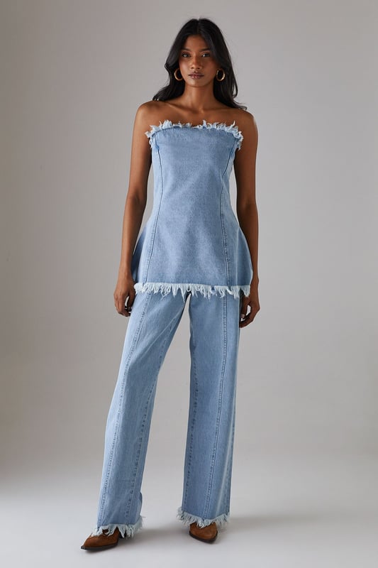 Wide leg silhouette with distinctive fray detailing at waistband and hem for an edgy finish
        Front seam detailing adds architectural interest and elongates the leg
        Cotton fabric provides comfort and breathability for all-day wear
        Practical side and back pockets for everyday functionality
        High-rise waist creates a flattering silhouette that pairs perfectly with cropped tops
    
    These Warehouse wide leg jeans combine contemporary design with effortless wearability. The striking fray detail along the waistband and hem creates a raw, fashion-forward aesthetic that sets these jeans apart from standard denim styles. Style them as shown with a simple fitted vest top for casual daytime outings, or dress them up with a tucked-in blouse and statement jewellery for lunch with friends. The cotton fabric ensures these jeans move comfortably with you throughout the day, while the front seam detailing creates a leg-lengthening effect. Perfect for weekend brunches, gallery visits or casual shopping trips, these jeans offer versatility without compromising on style. Complete the look with flat loafers or trainers for an understated daytime ensemble, or add a structured jacket for a more polished finish.