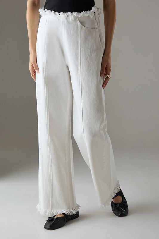 Wide leg silhouette with distinctive fray detailing at waistband and hem for an edgy finish
        Front seam detailing adds architectural interest and elongates the leg
        Cotton fabric provides comfort and breathability for all-day wear
        Practical side and back pockets for everyday functionality
        High-rise waist creates a flattering silhouette that pairs perfectly with cropped tops
    
    These Warehouse wide leg jeans combine contemporary design with effortless wearability. The striking fray detail along the waistband and hem creates a raw, fashion-forward aesthetic that sets these jeans apart from standard denim styles. Style them as shown with a simple fitted vest top for casual daytime outings, or dress them up with a tucked-in blouse and statement jewellery for lunch with friends. The cotton fabric ensures these jeans move comfortably with you throughout the day, while the front seam detailing creates a leg-lengthening effect. Perfect for weekend brunches, gallery visits or casual shopping trips, these jeans offer versatility without compromising on style. Complete the look with flat loafers or trainers for an understated daytime ensemble, or add a structured jacket for a more polished finish.