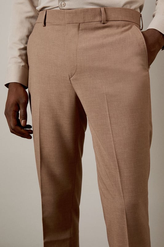 Slim fit design with a contemporary tapered leg for a refined silhouette
        Textured woven fabric adds subtle depth and visual interest
        Clean front with belt loops and side pockets for practicality
        Back pockets with button closure for secure storage
        Crisp centre crease for a sharp, professional finish
    
    These textured slim fit trousers from Burton deliver sophisticated style with modern appeal. The tailored silhouette creates a sleek profile that flatters without restricting movement-perfect for the gentleman who appreciates classic styling with contemporary proportions. Pair with the matching jacket as seen on our model for a complete suit that works brilliantly for formal occasions, or dress down with a crisp Oxford shirt for smart-casual events. The versatile trousers transition effortlessly from office meetings to evening drinks at your local. For a polished weekend look, team with a quality knitted jumper and leather loafers. These trousers offer the perfect balance of comfort and style for the man who values both tradition and contemporary fashion sensibilities.