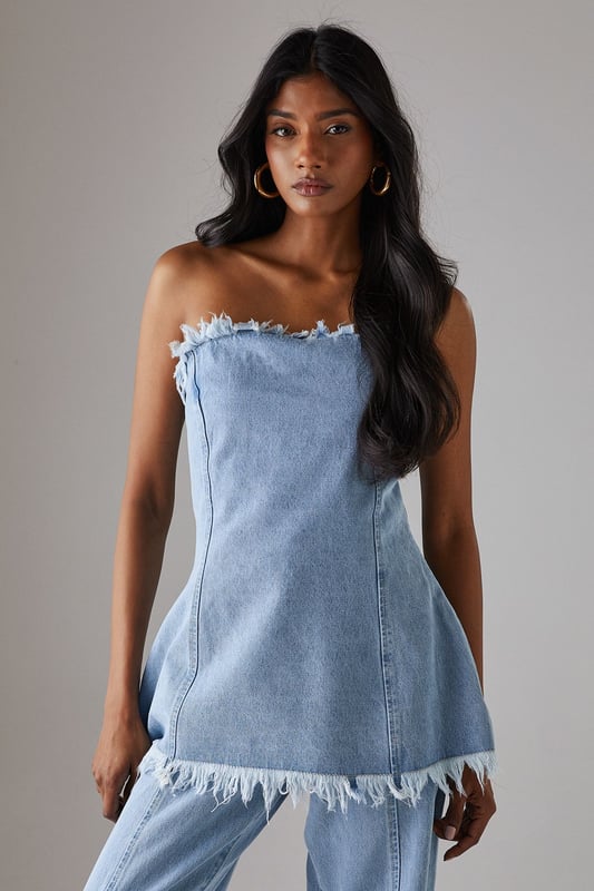 Strapless bandeau design with distinctive frayed edge detailing along the top and bottom hems
        Structured cotton denim fabric provides excellent shape retention and support
        Flattering A-line silhouette that gently flares from the bust to create a feminine profile
        Versatile length that works perfectly as a standalone top or layered piece
        Visible seam detailing adds architectural interest and enhances the contemporary aesthetic
    
    This Warehouse denim bandeau top brings effortless edge to your daywear collection. The raw, frayed edges create a deliberately undone finish that contrasts beautifully with the structured silhouette. Style with the matching frayed denim trousers for a coordinated set that makes a statement, or break it up with your favourite high-waisted jeans for a double denim moment. For casual outings, pair with trainers and oversized gold hoops for an ensemble that transitions seamlessly from weekend brunches to afternoon shopping trips. The cotton fabric offers breathable comfort whilst maintaining its shape throughout the day. This piece embodies Warehouse's confident, feminine aesthetic - perfect for the fashion-forward woman who appreciates contemporary design with a touch of attitude.