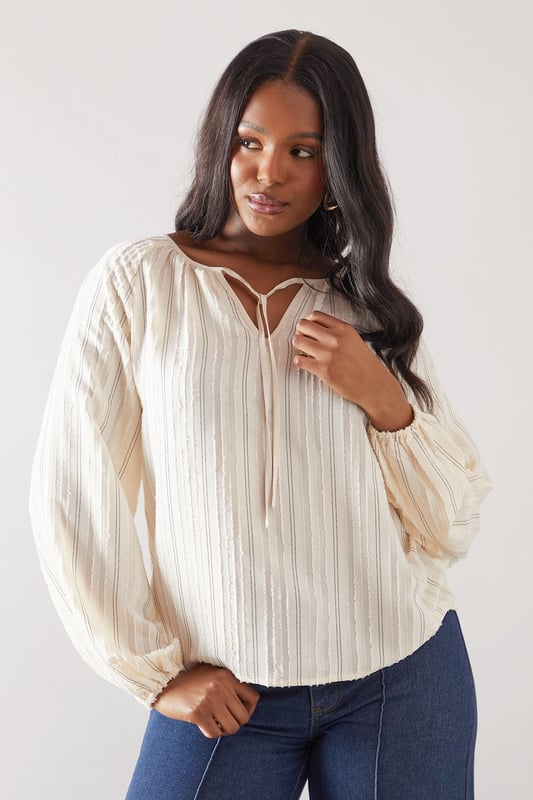 Elegant striped woven top with delicate embroidery detail throughout
        Feminine tie-front closure with keyhole neckline for a sophisticated touch
        Flattering gathered neckline creating a soft, flowing silhouette
        Voluminous balloon sleeves with elasticated cuffs for comfort and style
        Relaxed fit design with a curved hem for versatile styling options
    
    This charming Wallis top combines comfort with effortless sophistication. The gathered neckline and balloon sleeves create a flattering silhouette that works beautifully for daytime occasions. Style with wide-leg denim trousers and sandals, as shown, for family lunches or casual gatherings. The embroidered stripe pattern adds texture and interest, making this piece stand out from basic tops in your collection. For cooler days, layer under a lightweight cardigan or denim jacket. The tie-front detail allows you to adjust the neckline to your preference, while the relaxed fit ensures all-day comfort without compromising on style. Perfect for weekend brunches, shopping trips or casual meet-ups with friends when you want to look polished yet feel comfortable.