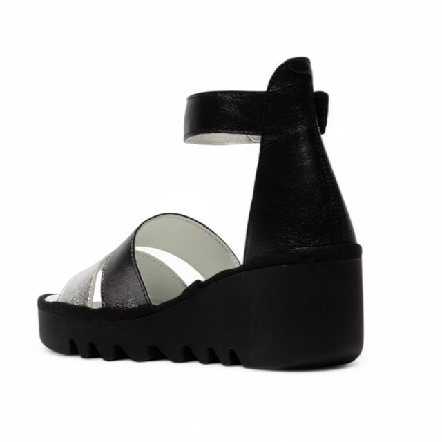 Luce estilo y comodidad con las sandalias BONO290FLY de la línea BLU de Fly London. Diseñadas para un uso cómodo, estas sandalias de cuña cuentan con una elegante parte superior de cuero, plantilla acolchada y una correa de tobillo segura para una sujeción óptima durante todo el día. Características principales: Parte superior de cuero de primera calidad: suave, duradera y elegante. Forro y plantilla de cuero: garantizan comodidad y transpirabilidad. Correa de tobillo ajustable con velcro: fácil de usar y con ajuste personalizado. Plantilla acolchada: proporciona sujeción y comodidad duraderas. Suela de cuña de goma TR resistente: mejora el agarre y la estabilidad. Tacón de cuña de 6,5 cm: aumenta la altura sin comprometer la comodidad.