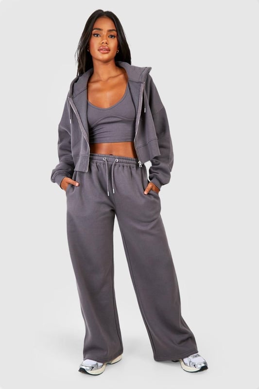 Three-piece tracksuit featuring a crop top, hoodie, and wide-leg trousers
        Seam detail adds a stylish touch to the ensemble
        Fleece-back fabric for comfort and warmth
        Hooded jacket with full-length zip closure
        Wide-leg trousers with an adjustable waistband for a customisable fit
    
    Embrace laid-back chic with this versatile three-piece tracksuit from Boohoo. Perfect for those who want to stay on-trend whilst prioritising comfort, this set is ideal for a range of casual occasions. The crop top can be worn alone on warmer days or layered under the hoodie when the temperature drops. The wide-leg trousers offer a contemporary silhouette that pairs beautifully with trainers for a street-style inspired look. For a casual day out, throw on the full set with some chunky jewellery and a cross-body bag. Alternatively, mix and match the pieces with other items in your wardrobe - try the hoodie with skinny jeans or the trousers with a fitted tee for endless styling possibilities. Whether you're heading to a laid-back brunch, running errands, or enjoying a cosy night in, this tracksuit has got you covered with its blend of style and comfort.