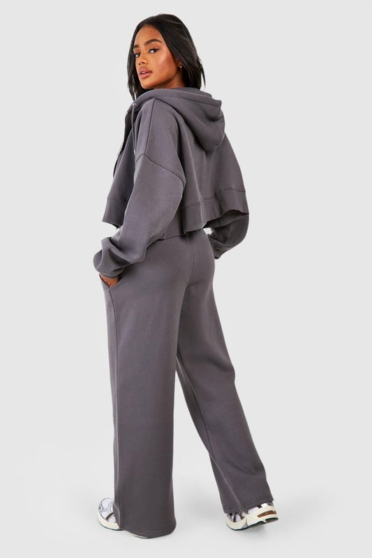 Three-piece tracksuit featuring a crop top, hoodie, and wide-leg trousers
        Seam detail adds a stylish touch to the ensemble
        Fleece-back fabric for comfort and warmth
        Hooded jacket with full-length zip closure
        Wide-leg trousers with an adjustable waistband for a customisable fit
    
    Embrace laid-back chic with this versatile three-piece tracksuit from Boohoo. Perfect for those who want to stay on-trend whilst prioritising comfort, this set is ideal for a range of casual occasions. The crop top can be worn alone on warmer days or layered under the hoodie when the temperature drops. The wide-leg trousers offer a contemporary silhouette that pairs beautifully with trainers for a street-style inspired look. For a casual day out, throw on the full set with some chunky jewellery and a cross-body bag. Alternatively, mix and match the pieces with other items in your wardrobe - try the hoodie with skinny jeans or the trousers with a fitted tee for endless styling possibilities. Whether you're heading to a laid-back brunch, running errands, or enjoying a cosy night in, this tracksuit has got you covered with its blend of style and comfort.