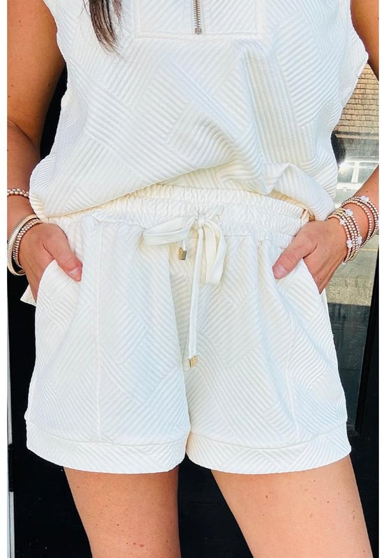 Our styles are designed with a trendy fitted look in mind following an international size standard. For the best fit we suggest choosing one size up from your usual. Be sure to check our sizing chart to find your perfect match!
  White textured short set
  Half
  zip cropped tank top
  Matching drawstring shorts
  Made from buttery soft fabric
  Ideal for casual wear
  Pairs well with sneakers and boots
Material: 97% Polyester 3% Elastane