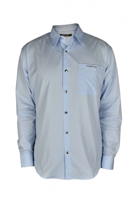 Camisa azul claro Roberto Cavalli.Bolsillo de parche con logotipo de monedas metálicas plateadas en el pecho.Parche con logotipo en la nuca.Cuello en punta.Mangas largas con puños de botones plateados.Cierre con botones plateados en la parte delantera.Made in Italy.