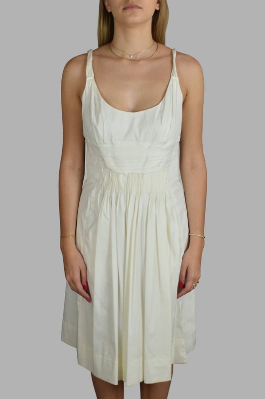 Vestido blanco de Prada.Efecto tejido plisado.Cierre de cremallera en la espalda.72% algodón, 23% poliamida, elastano.Made in Italy.