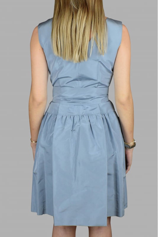 Vestido azul Prada con escote en pico.Cinturón ajustable y extraíble en la cintura.Bolsillos en la cintura.100% seda.Made in Italy.