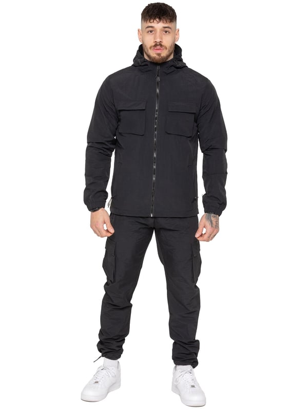 The Enzo Milano Men’s Lightweight Cargo Jacket is a sleek, functional outer layer made from water-repellent crushed poly fabric with a breathable mesh lining for all-day comfort. Designed in a regular fit, it features a full zip front, high neck, and adjustable drawcord hood for versatile coverage. With two Velcro chest pockets, two zippered side pockets, elasticated cuffs, and an adjustable drawcord hem, it offers both style and practicality—perfect for layering in changing weather.