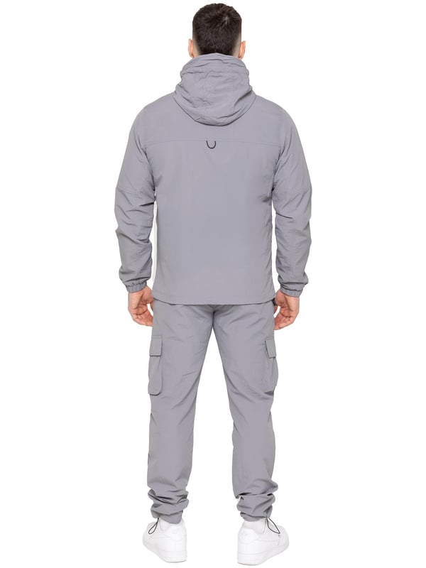 The Enzo Milano Men’s Lightweight Cargo Jacket is a sleek, functional outer layer made from water-repellent crushed poly fabric with a breathable mesh lining for all-day comfort. Designed in a regular fit, it features a full zip front, high neck, and adjustable drawcord hood for versatile coverage. With two Velcro chest pockets, two zippered side pockets, elasticated cuffs, and an adjustable drawcord hem, it offers both style and practicality—perfect for layering in changing weather.