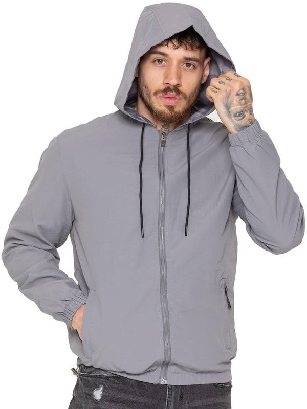La chaqueta cortavientos para hombre de Enzo Milano ofrece un diseño elegante, ligero y de ajuste regular. Confeccionada en resistente tejido técnico, cuenta con cremallera completa, capucha ajustable con cordón y puños elásticos para mayor comodidad y protección. Con dos bolsillos laterales ocultos con cremallera, un bolsillo interior y un bajo elástico con cordón ajustable, esta chaqueta repelente al agua es ideal para el uso diario en días de lluvia ligera o con viento. Acabada con el distintivo parche de goma de Enzo Milano para un toque de estilo.