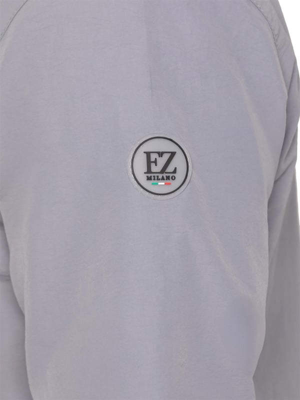 La chaqueta cortavientos para hombre de Enzo Milano ofrece un diseño elegante, ligero y de ajuste regular. Confeccionada en resistente tejido técnico, cuenta con cremallera completa, capucha ajustable con cordón y puños elásticos para mayor comodidad y protección. Con dos bolsillos laterales ocultos con cremallera, un bolsillo interior y un bajo elástico con cordón ajustable, esta chaqueta repelente al agua es ideal para el uso diario en días de lluvia ligera o con viento. Acabada con el distintivo parche de goma de Enzo Milano para un toque de estilo.