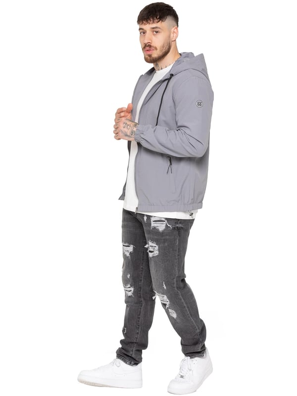 La chaqueta cortavientos para hombre de Enzo Milano ofrece un diseño elegante, ligero y de ajuste regular. Confeccionada en resistente tejido técnico, cuenta con cremallera completa, capucha ajustable con cordón y puños elásticos para mayor comodidad y protección. Con dos bolsillos laterales ocultos con cremallera, un bolsillo interior y un bajo elástico con cordón ajustable, esta chaqueta repelente al agua es ideal para el uso diario en días de lluvia ligera o con viento. Acabada con el distintivo parche de goma de Enzo Milano para un toque de estilo.