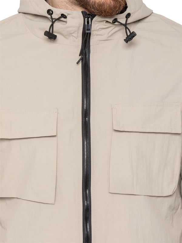 The Enzo Milano Men’s Lightweight Cargo Jacket is a sleek, functional outer layer made from water-repellent crushed poly fabric with a breathable mesh lining for all-day comfort. Designed in a regular fit, it features a full zip front, high neck, and adjustable drawcord hood for versatile coverage. With two Velcro chest pockets, two zippered side pockets, elasticated cuffs, and an adjustable drawcord hem, it offers both style and practicality—perfect for layering in changing weather.