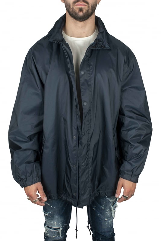Chaqueta impermeable azul en nailon de Balenciaga.Logotipo blanco en la espalda con varias caligrafías.Cierre con botones de presión.Cuello alto con capucha desmontable.Mangas largas.Bolsillos laterales.Cintura y mangas elásticas.Made in Italy.