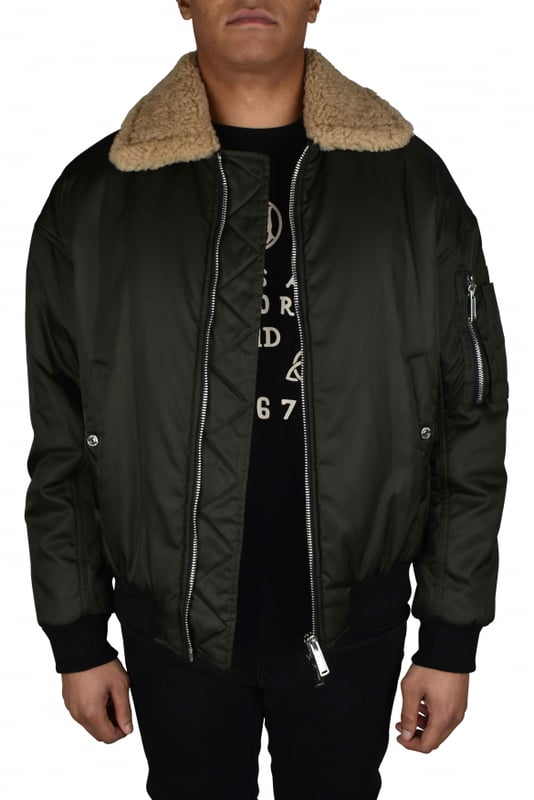 Chaqueta bomber de nailon verde caqui de dsquared2.Cuello de borreguillo color hueso.Hoja de arce y logotipo estampados en amarillo en la espalda.Dos bolsillos laterales con botones a presión.Un bolsillo con cremallera en la manga.Cierre con cremallera.Manga larga.Cintura elástica negra.Bordes acanalados.Made in Italy.