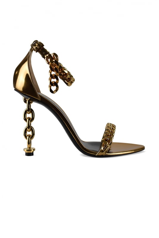 Sandalias Tom Ford en piel metalizada dorada.Estilo de tiras. Cadena dorada en la tira delantera del tobillo.Hebilla en el tobillo.Acabados dorados.Tacón de cadena dorada.Puntera abierta en punta.Altura del tacón 10 cm.Made in Italy.
