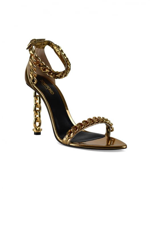 Sandalias Tom Ford en piel metalizada dorada.Estilo de tiras. Cadena dorada en la tira delantera del tobillo.Hebilla en el tobillo.Acabados dorados.Tacón de cadena dorada.Puntera abierta en punta.Altura del tacón 10 cm.Made in Italy.